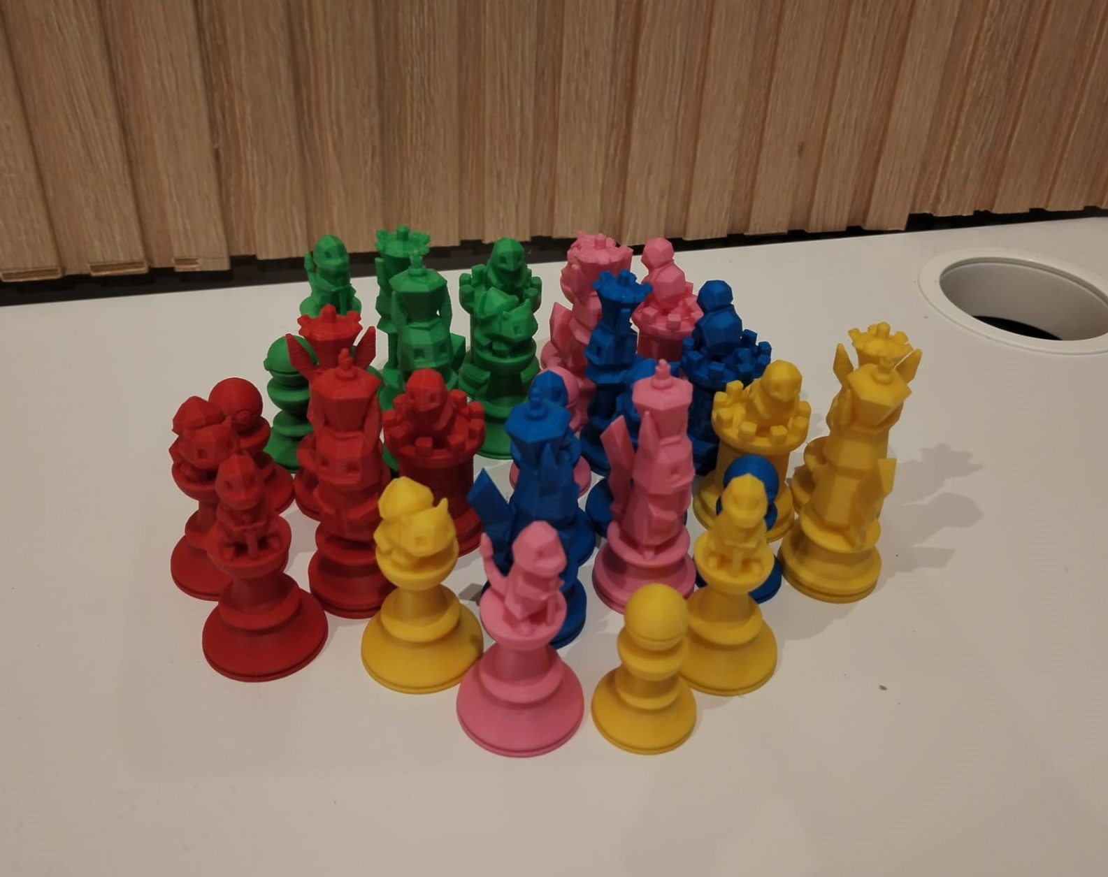 Piezas de ajedrez impresas en 3D en rojo, verde, amarillo, rosa y azul